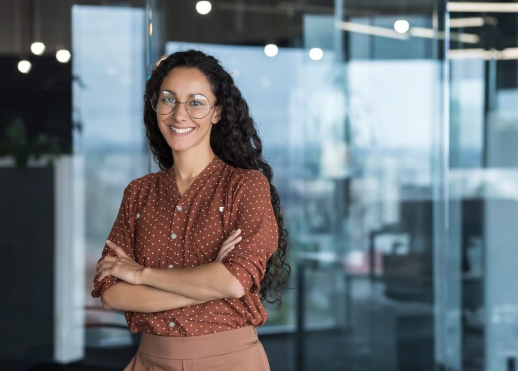 Portrait of Hispanic woman. Curly Latin American student stands in the hall of the university